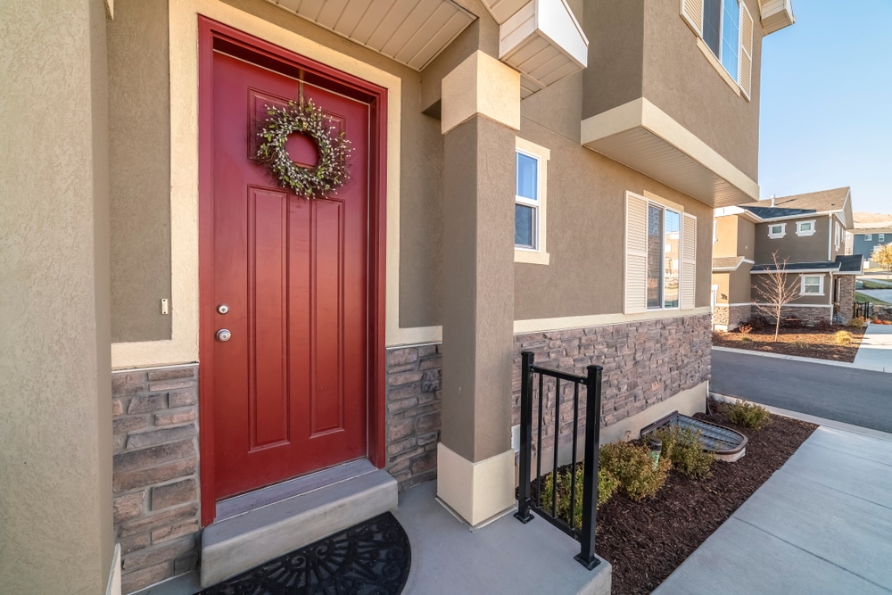 Suburban house with a red front door, accented with a decorative wreath